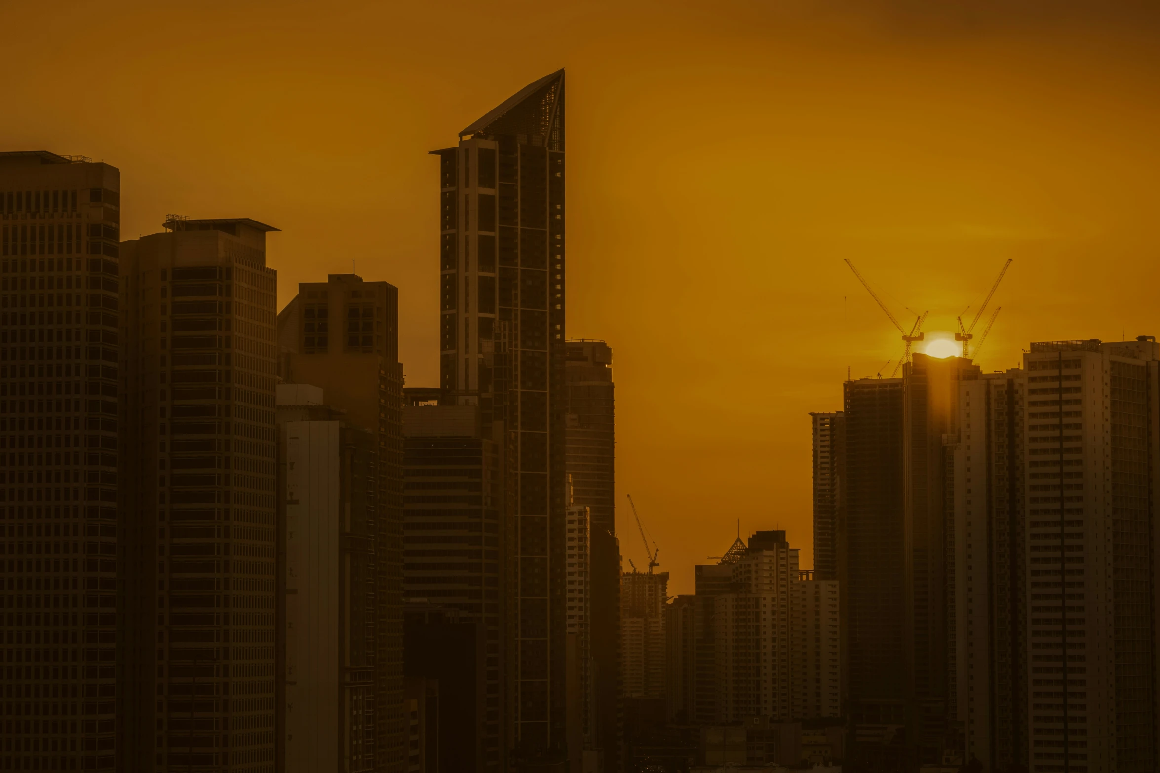 the setting sun is seen in front of the large city