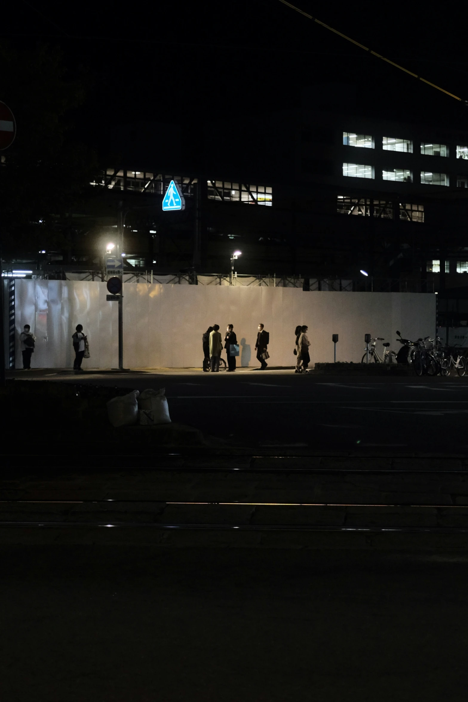 people standing in the dark near a building