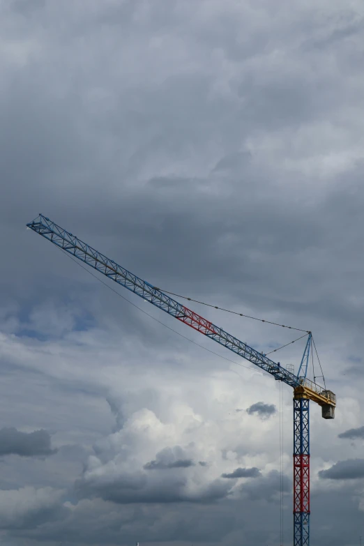 a large crane on the beach under a cloudy sky