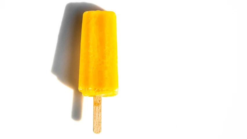 yellow food item with dark shadow on white background