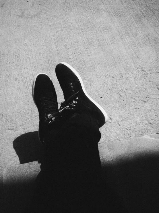 the shadow of a person wearing black shoes