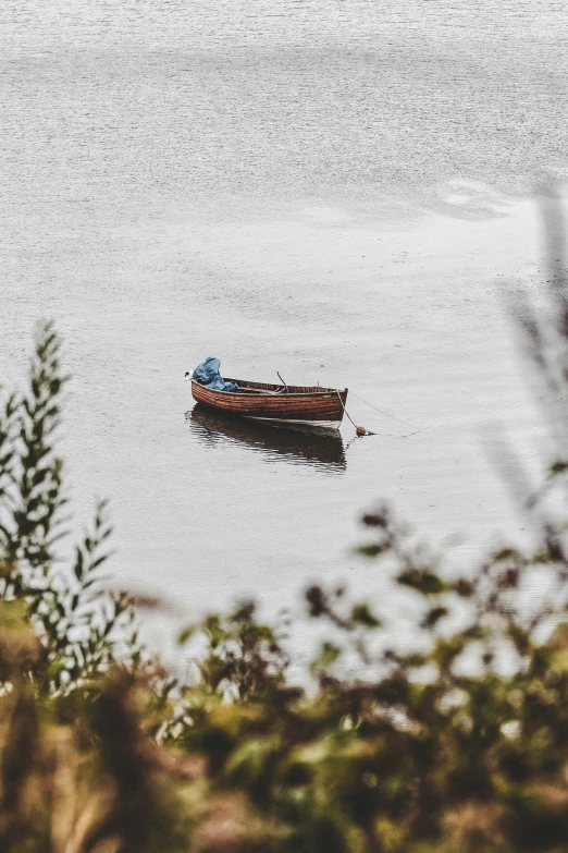 a boat floating on top of a lake near water