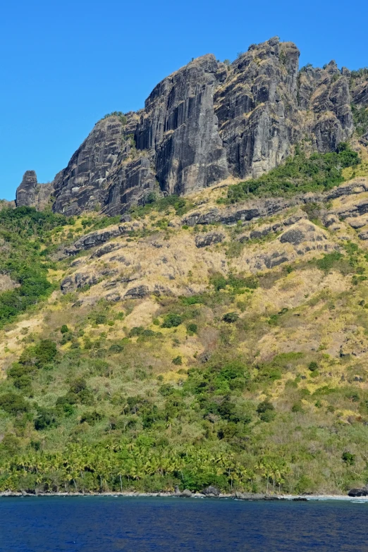 the mountains above are rocky and have many green trees