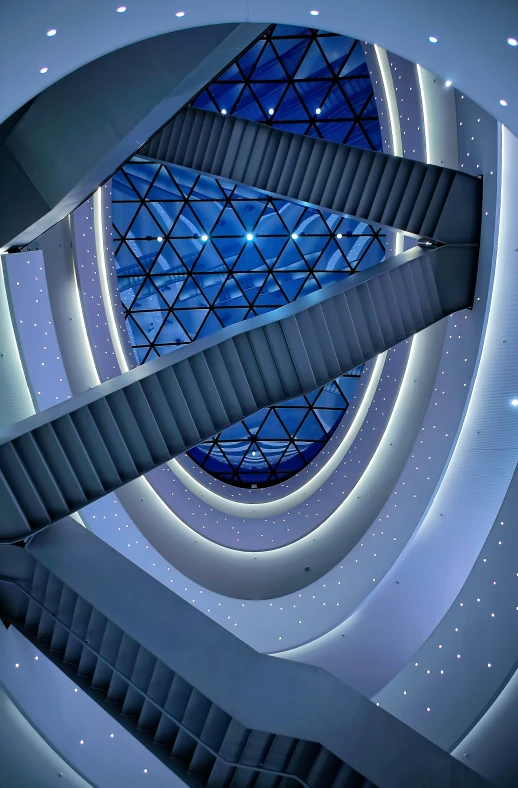 a spiral staircase at a museum with blue glass