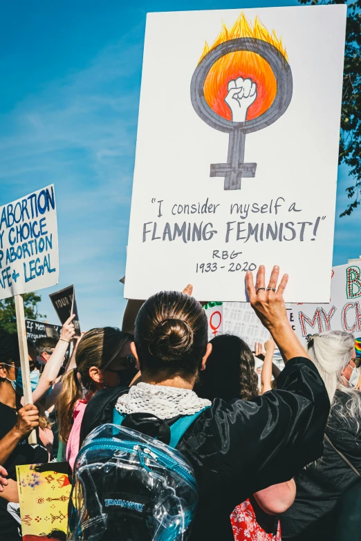 a person holding a sign while someone holds their hand up