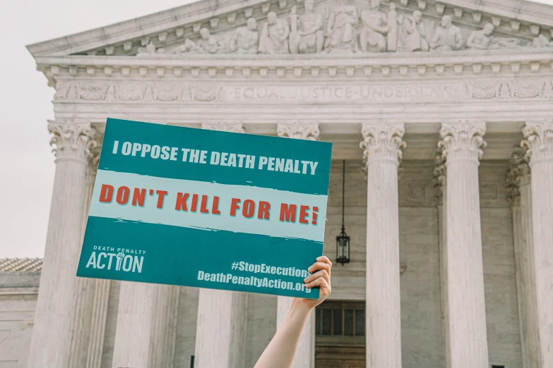 a woman holding a protest sign up in front of the u s supreme court