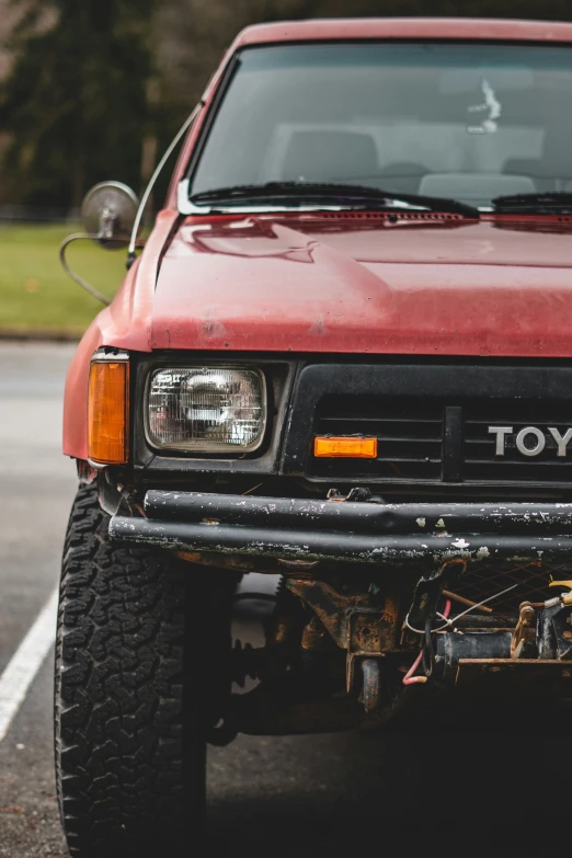 the front end of a red truck sitting on top of a road