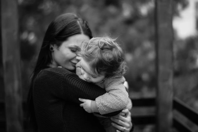 mother and baby holding each other outside in the park