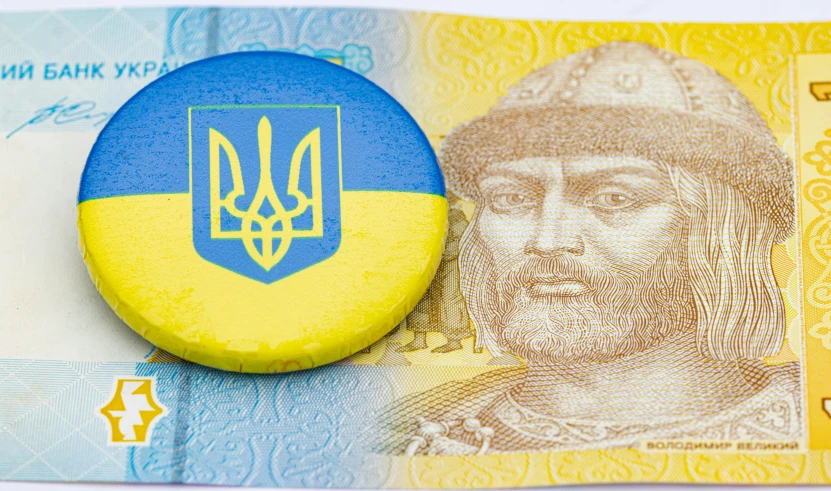 a blue and yellow badge sitting on a blue and yellow money bill