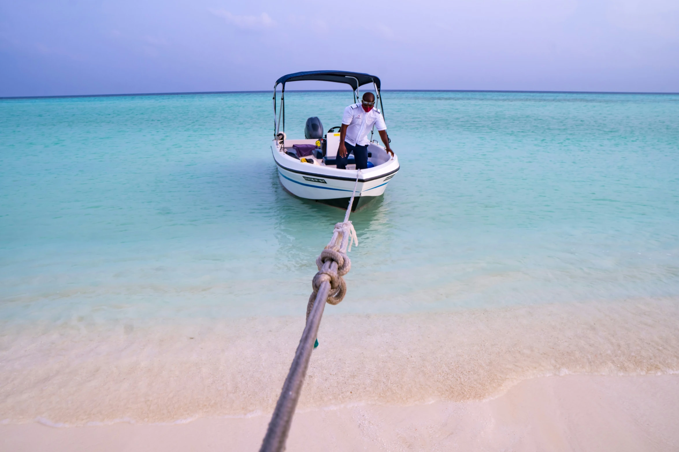 a man on a small boat tied to an anchor