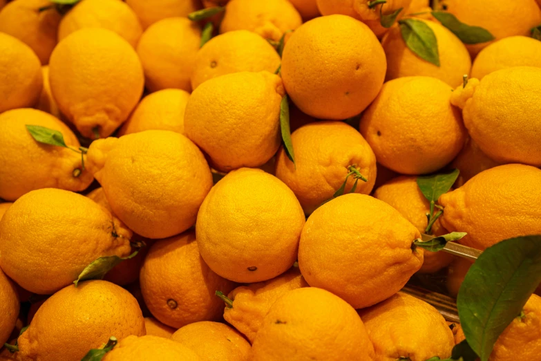 a large pile of yellow lemons next to each other