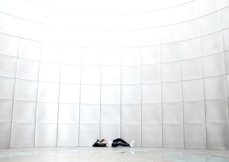 a couple of people standing in front of a white wall