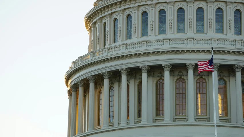 a large white building with columns and an american flag flying outside