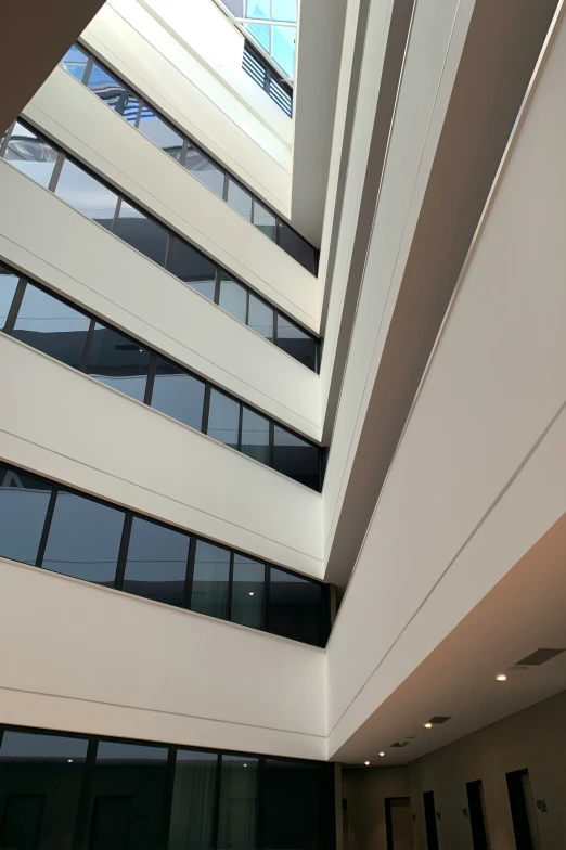 an atrium with several windows has a few bars in the ceiling