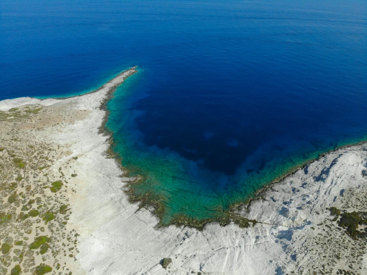 a beautiful blue hole surrounded by white sand