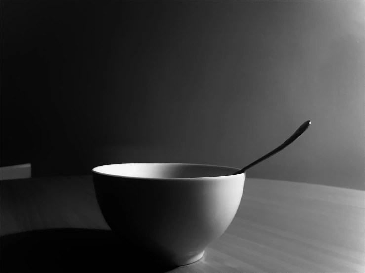 a bowl with a spoon inside of it on a table