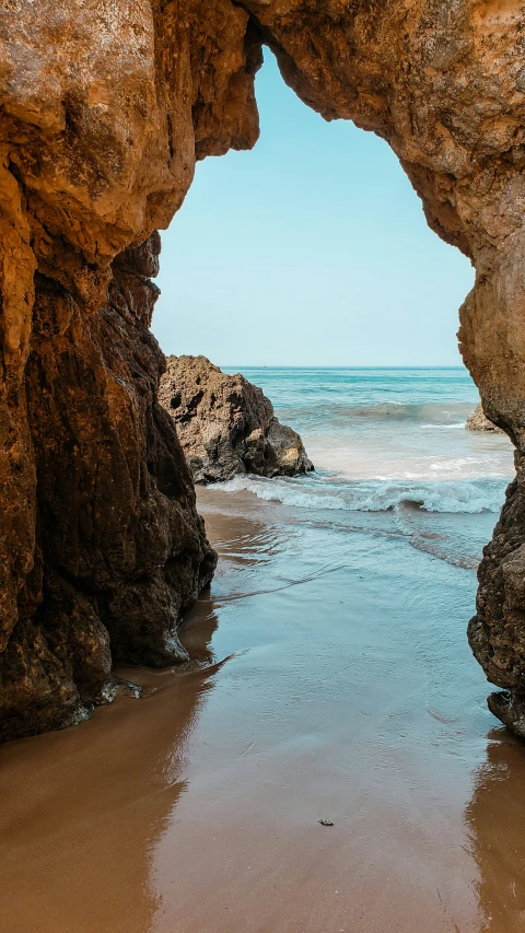 a cave near the water that is opened to the beach