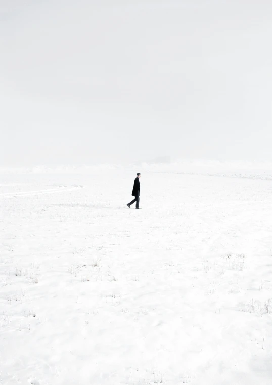 an alone person in the middle of a snowy field