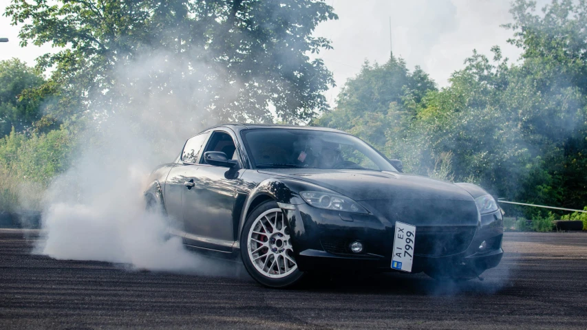 a very shiny car driving through a lot of smoke