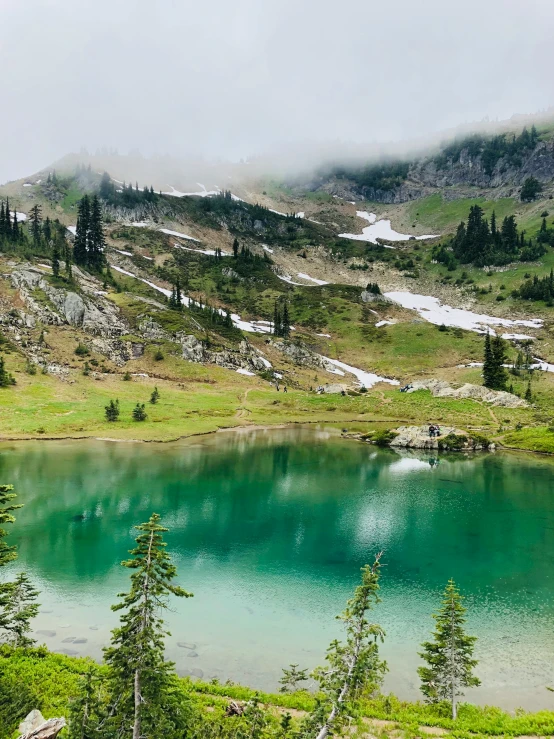 mountains and lakes surrounded by grass and trees