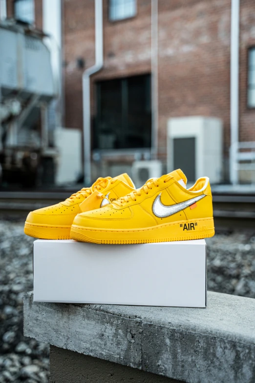 yellow sneakers with white writing sit on a ledge outside