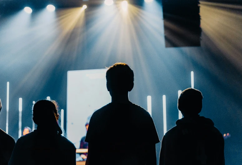 group of people in front of a big screen