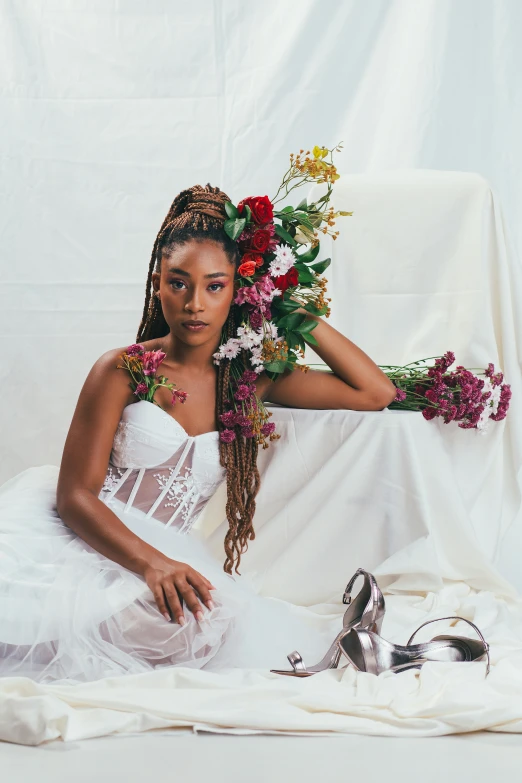 a young african woman poses for the camera holding flowers