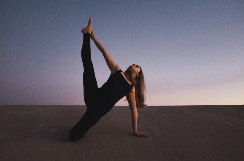 a woman is doing yoga in the desert