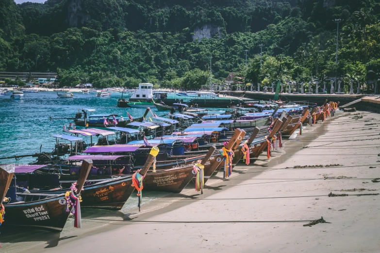 row of colorfully decorated boats sit along the water