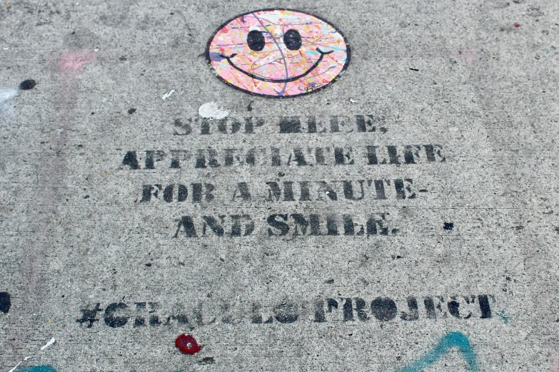 a sidewalk with graffiti on it reads stop and be happy