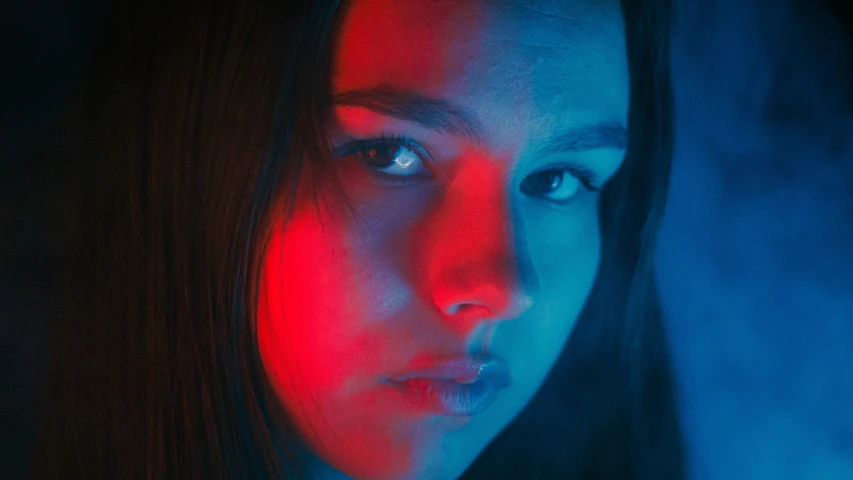 a woman standing with her face lit from behind