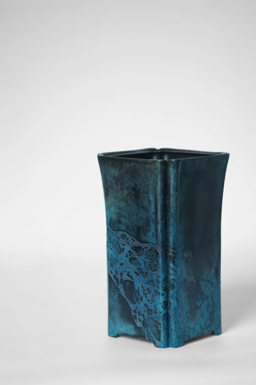 blue vase with black swirled design on it