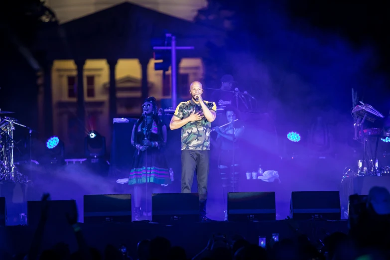 a man standing in front of a microphone on stage