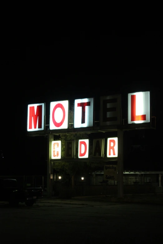 a motel building with lit up letters at night