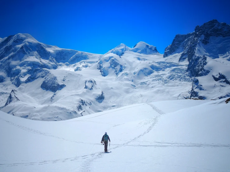 a skier trekking on a snow covered hill