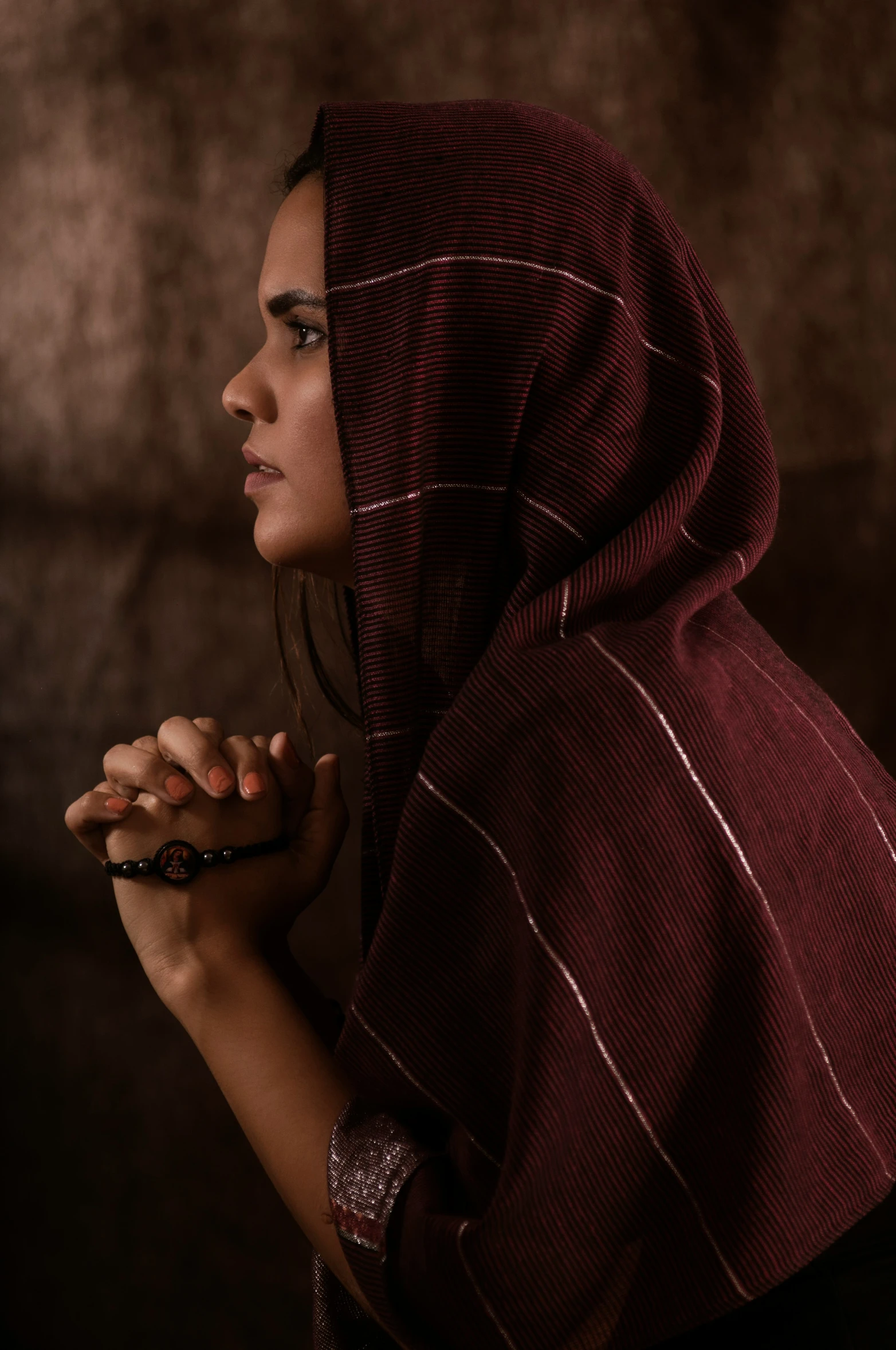 a woman with her hands together while wearing a red outfit