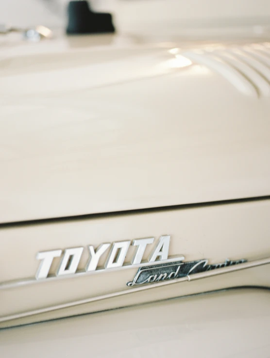 toyota emblem on an old beige car parked