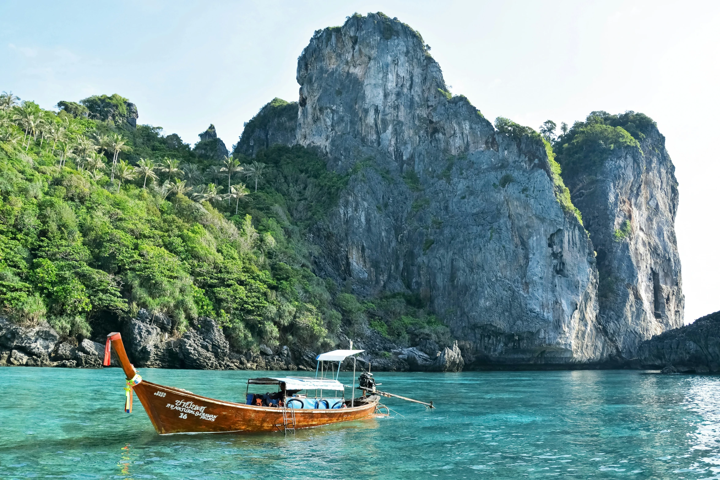 boats on clear blue water surrounded by mountains