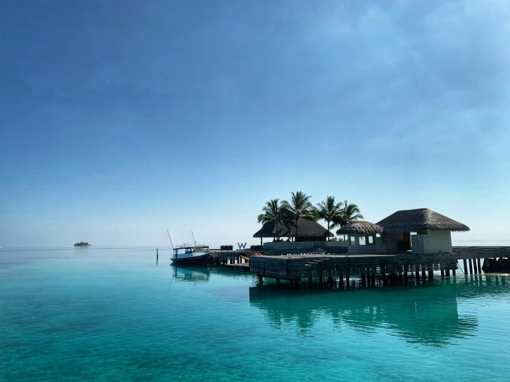 a hut on the end of a wooden pier in an ocean