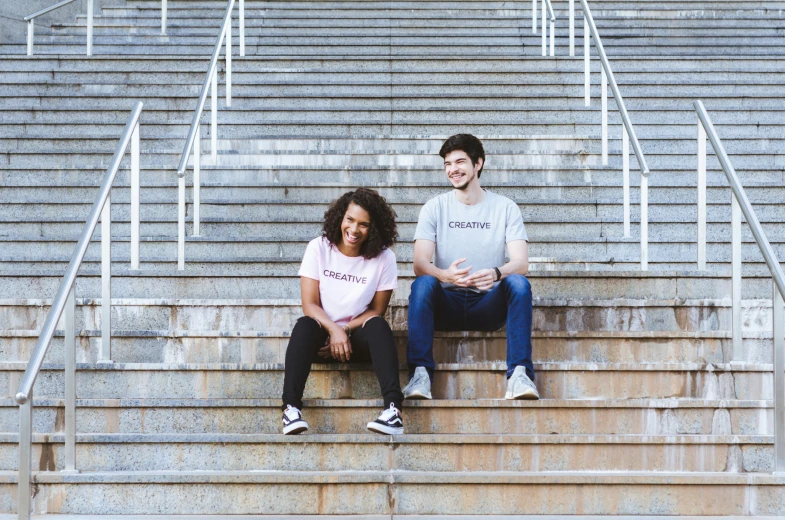 two people sitting on some steps near the seats