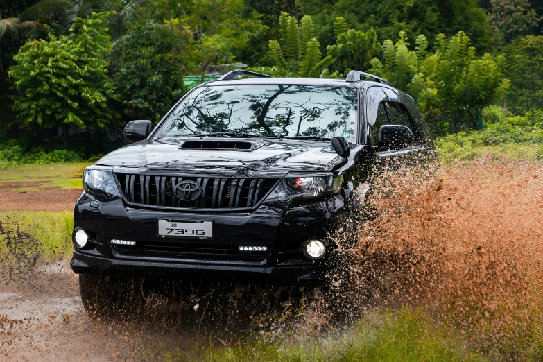 a black suv in the mud on a road