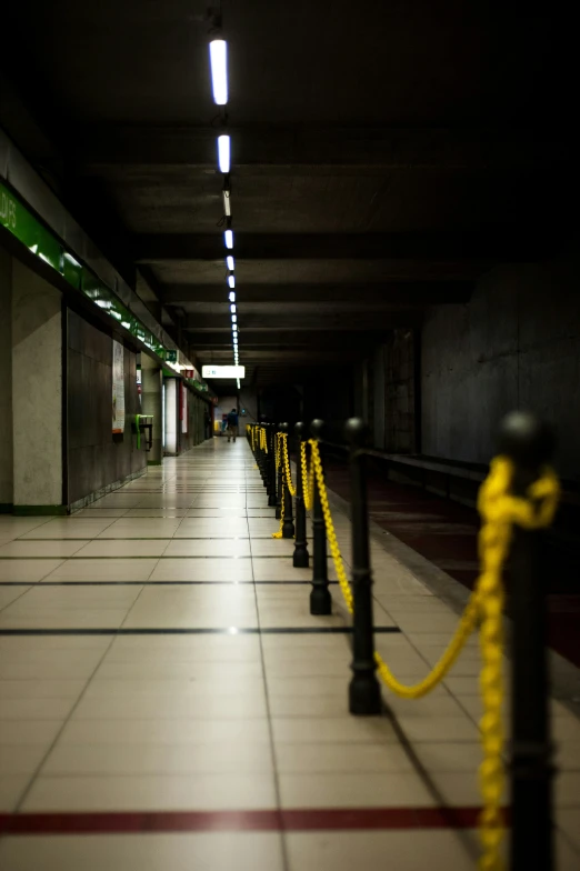 an empty hallway that has yellow ropes on the floor