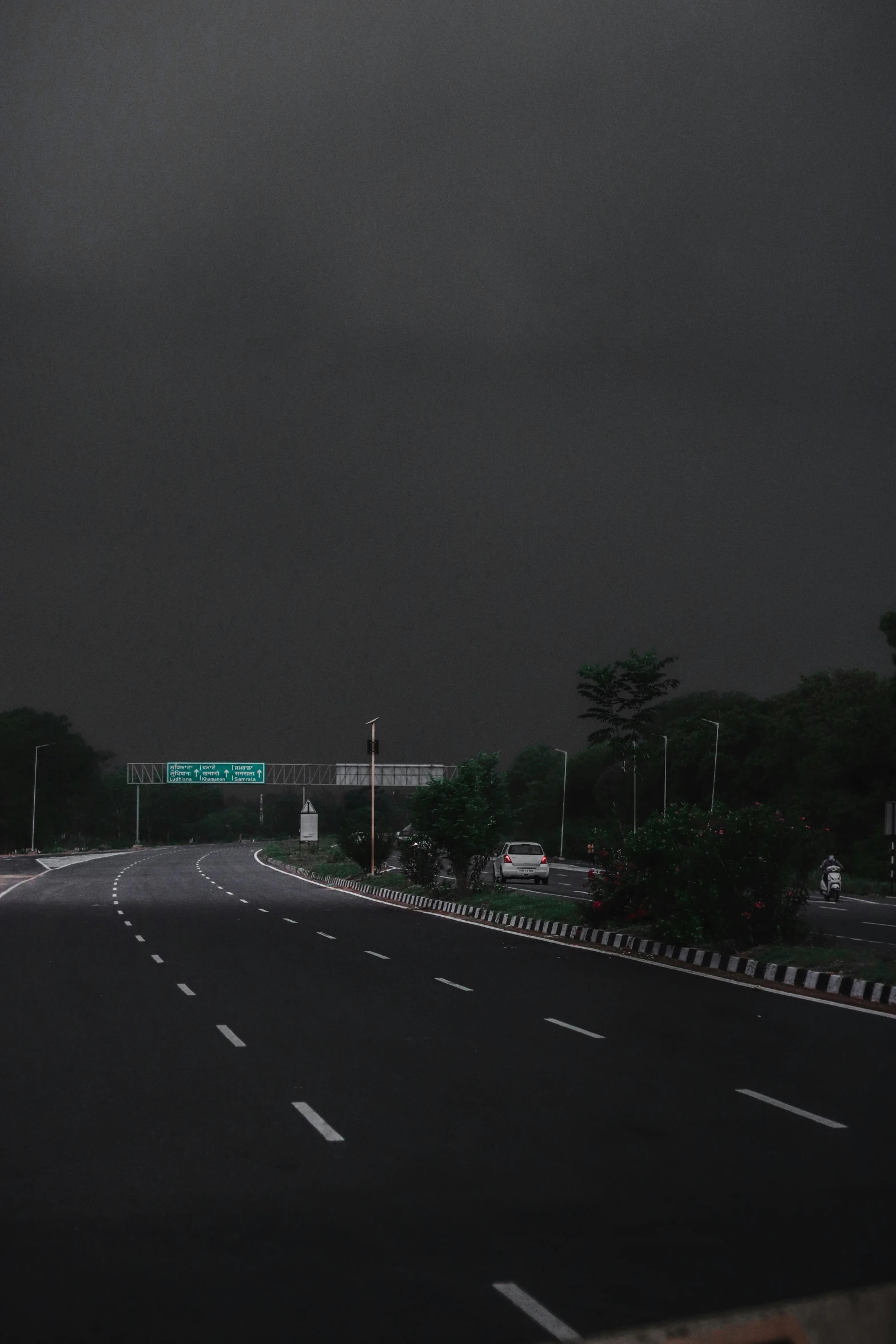 an empty road with street signs and a light on it