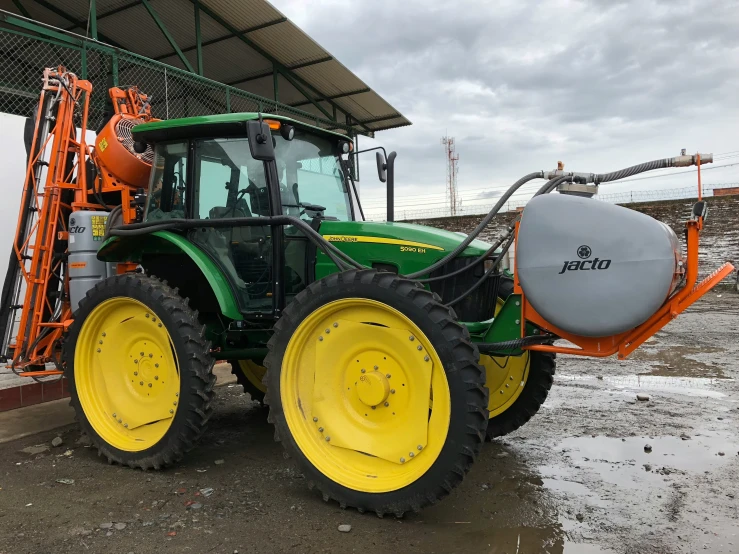 a green tractor parked under an awning