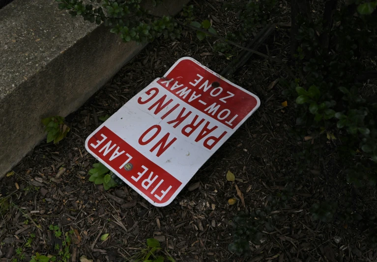 a warning sign laying on the ground in the dirt