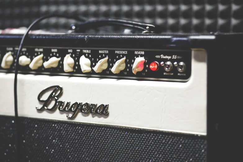 a guitar amplifier sitting next to a checkered wall