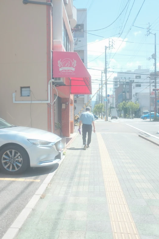 a man with a suitcase walking on the sidewalk