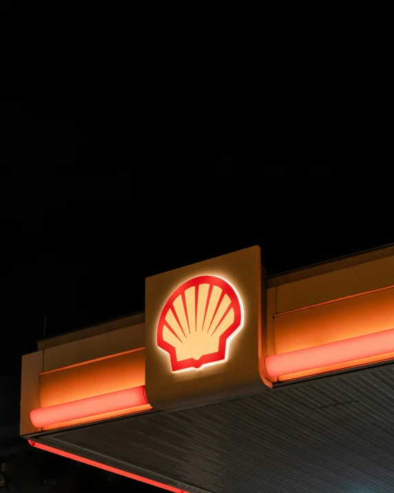 the logo for the shell gas station lit up at night