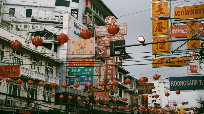 red chinese lanterns hung in the air above buildings