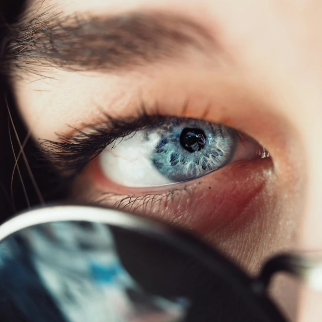 a close - up view of a blue eye looking through the frame